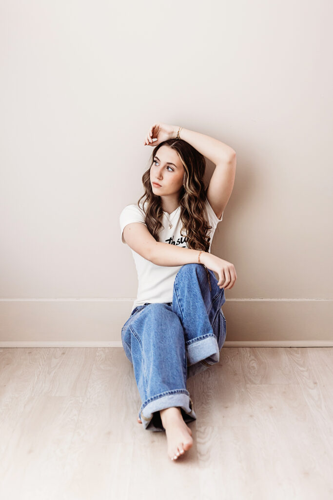 Addy seated barefoot on the studio floor with one arm resting overhead, soft curls and thoughtful gaze at Reflection Images by Tracy Rowell in Florence SC