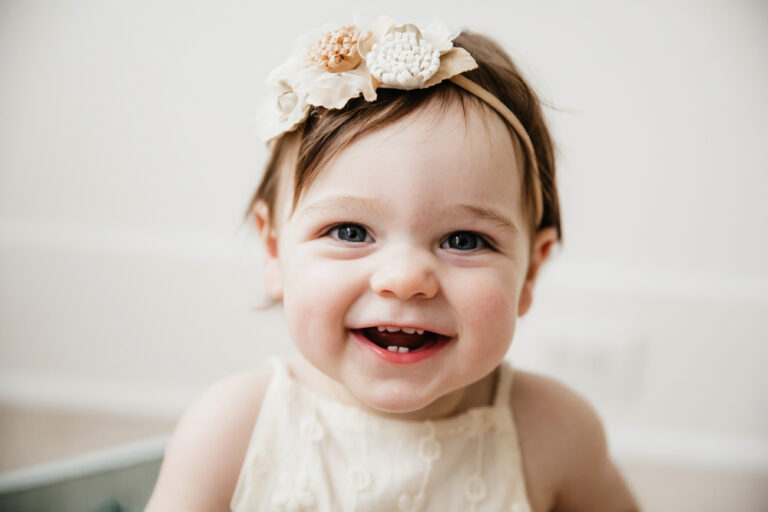 05-05-aubrey-closeup-white-flower-headband Close-up of Aubreys face with white flower headband and sweet smile in soft neutral light at Reflection Images by Tracy Rowell in Florence SC
