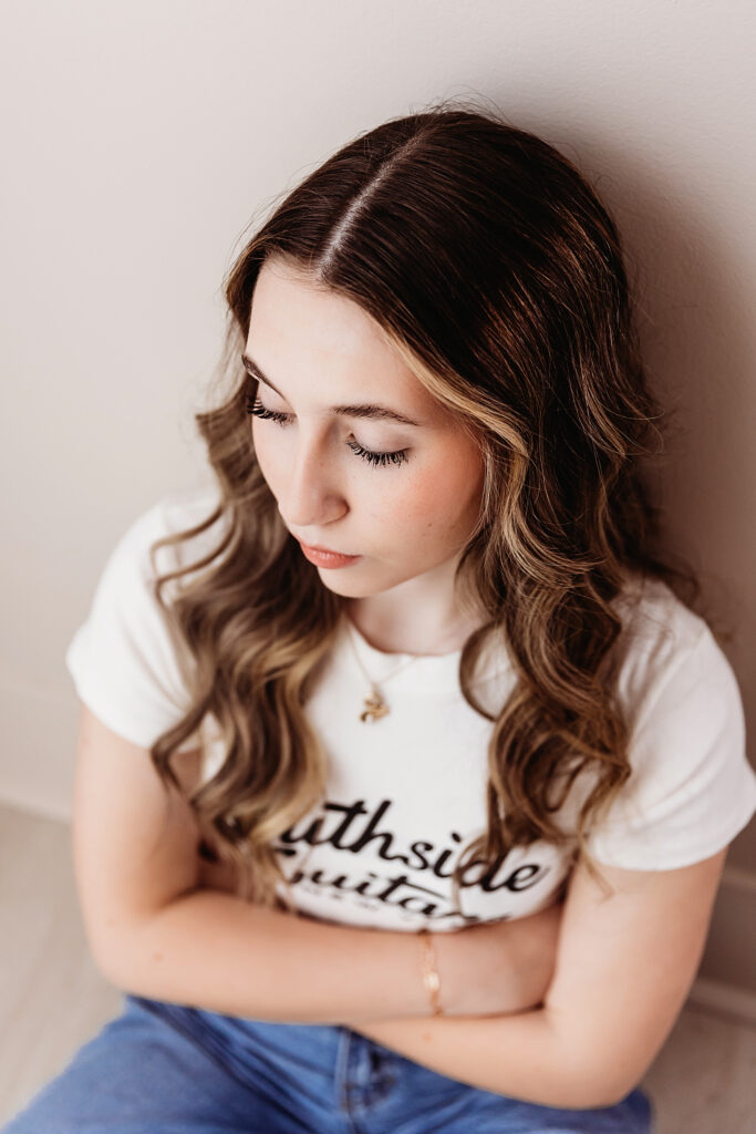 Top-down close-up of Addyâ€™s closed eyes and long lashes, soft curls framing her face as she rests against the wall at Reflection Images by Tracy Rowell in Florence SC