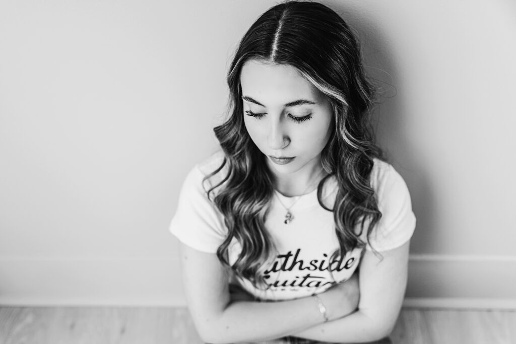 Black and white macro portrait of Addy with eyes closed, soft curls and peaceful expression from a top-down angle at Reflection Images by Tracy Rowell in Florence SC