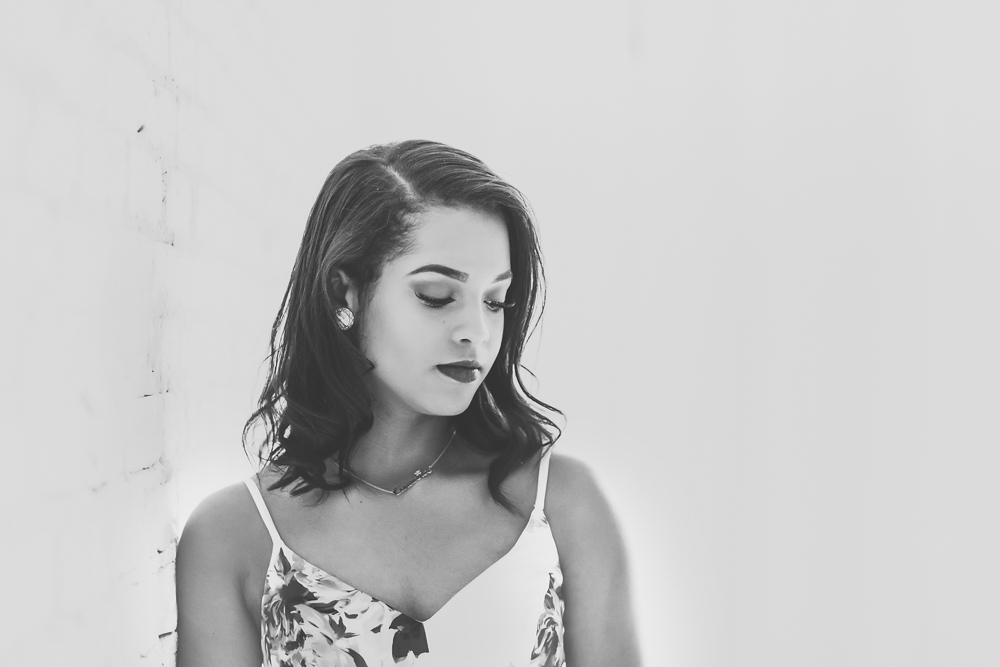 Black and white portrait of Connie with a graceful expression, wearing a floral dress and pearl earrings at Reflection Images by Tracy Rowell in Florence SC