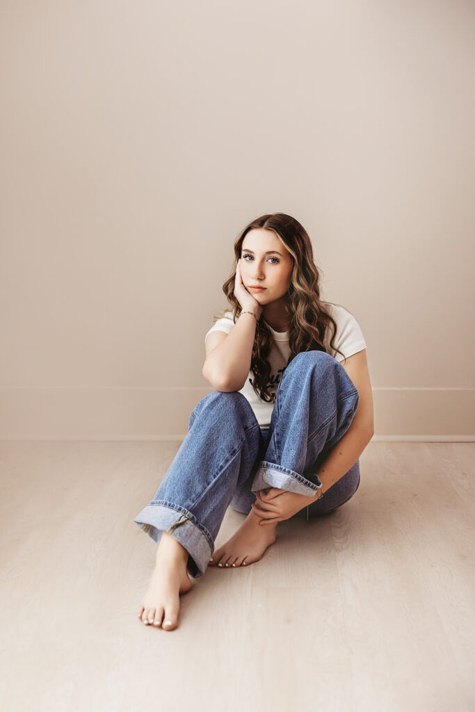 Addy barefoot in a seated floor pose with hand on her cheek, thoughtful expression and relaxed styling at Reflection Images by Tracy Rowell in Florence SC