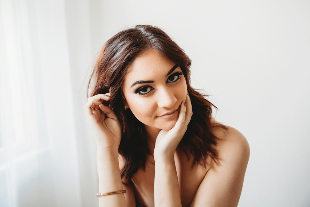 Patricia resting her chin on her hand with subtle smile and strapless patterned top at Reflection Images by Tracy Rowell in Florence SC