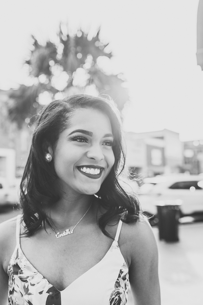 Black and white candid of Connie laughing with a palm tree silhouette behind her downtown at Reflection Images by Tracy Rowell in Florence SC