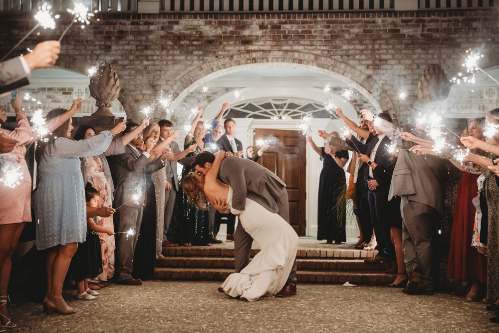 Couple kissing in sparkling exit with cheering guests at Reflection Images by Tracy Rowell in Florence SC