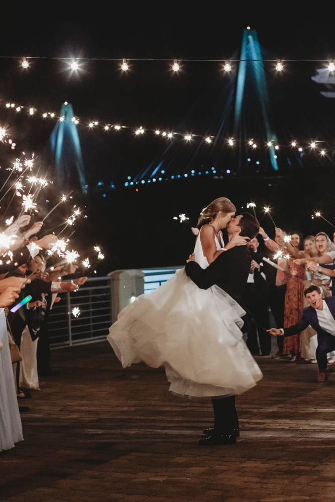 Wedding moment couple kiss during sparkler exit, captured by tracy rowell.