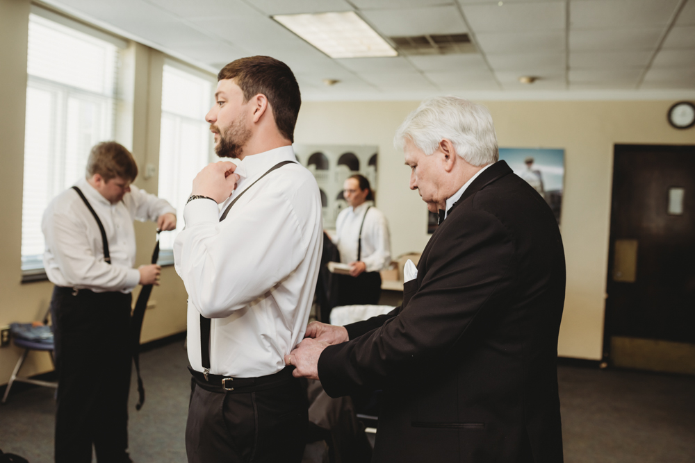 Wedding moment during groomsmen group shot, captured by reflection images by tracy rowell.