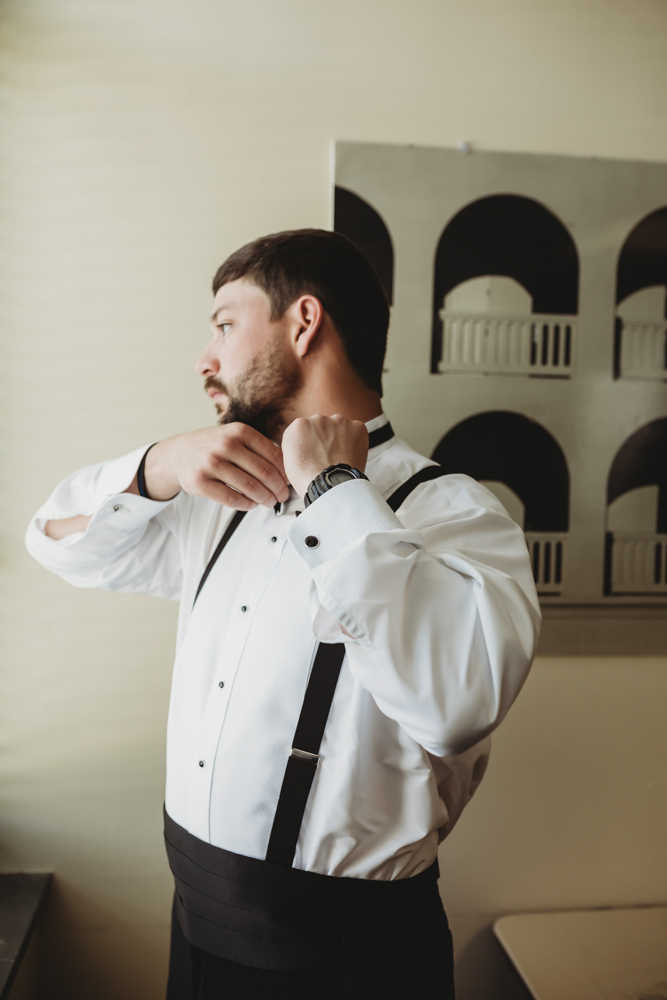 Wedding moment during groomsmen group shot, captured by reflection images by tracy rowell.