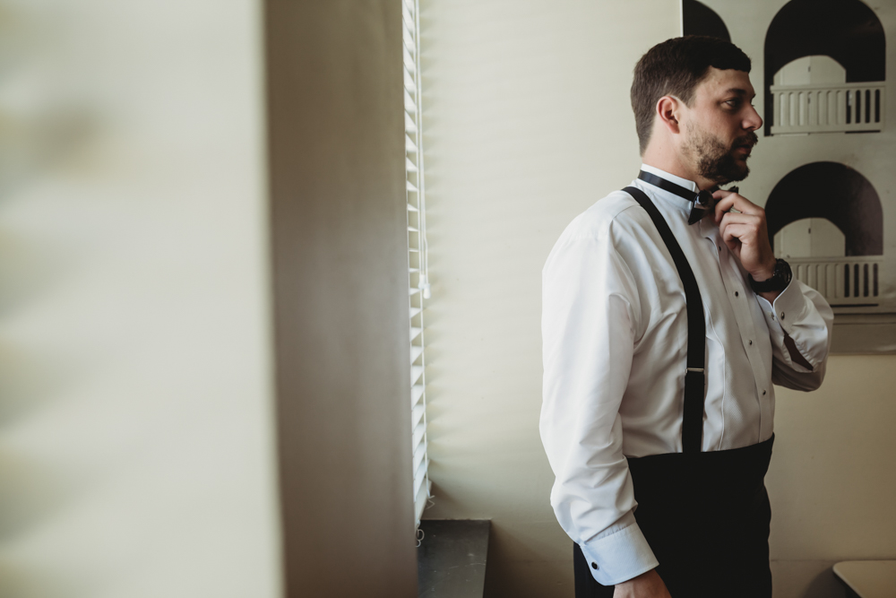 Wedding moment during groomsmen group shot, captured by reflection images by tracy rowell.