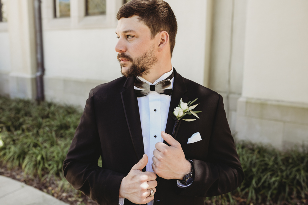 Wedding moment during groomsmen group shot, captured by reflection images by tracy rowell.
