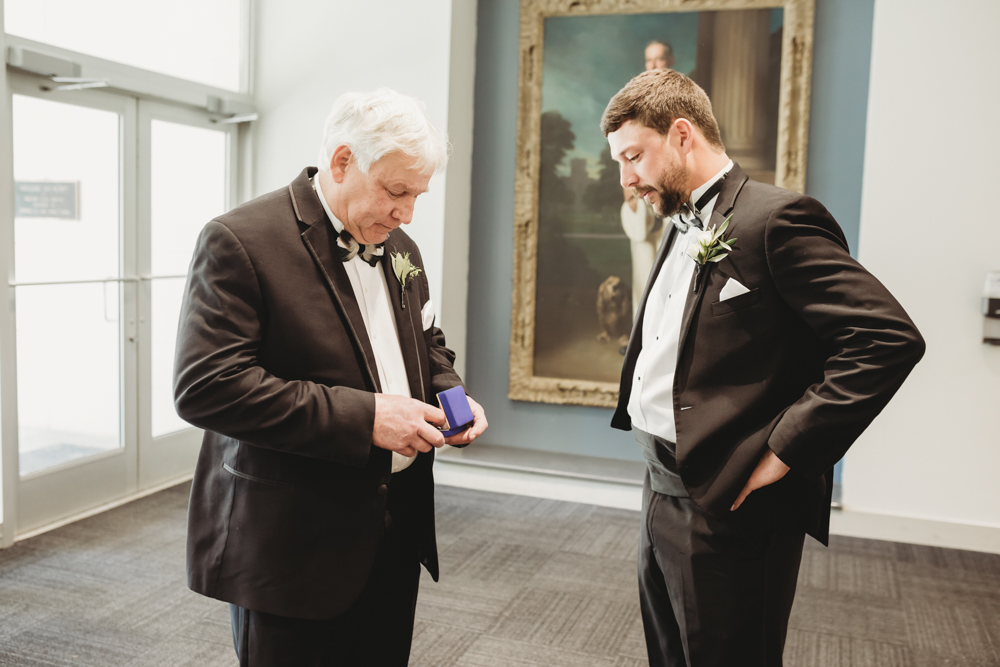 Wedding moment during groomsmen group shot, captured by reflection images by tracy rowell.