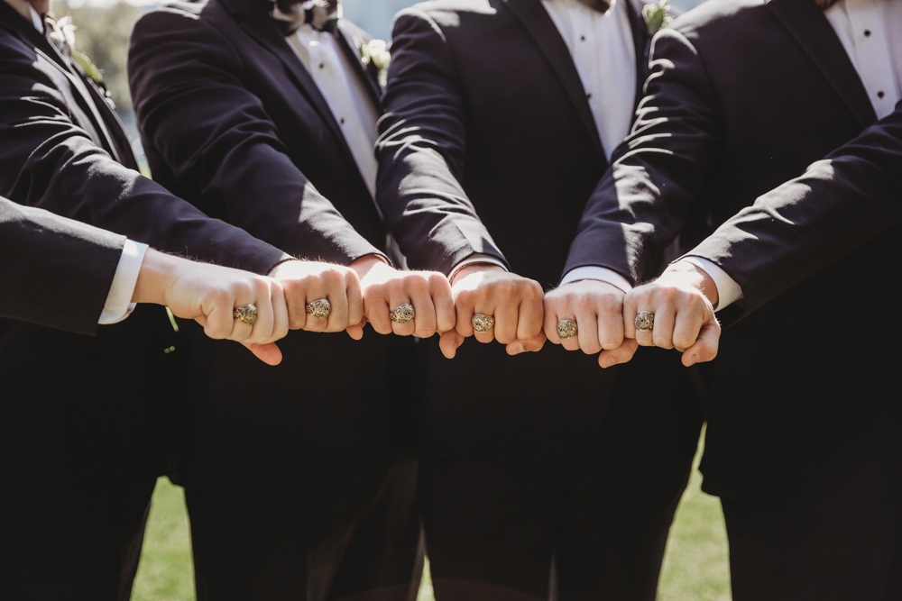 Wedding moment during groomsmen group shot, captured by tracy rowell.