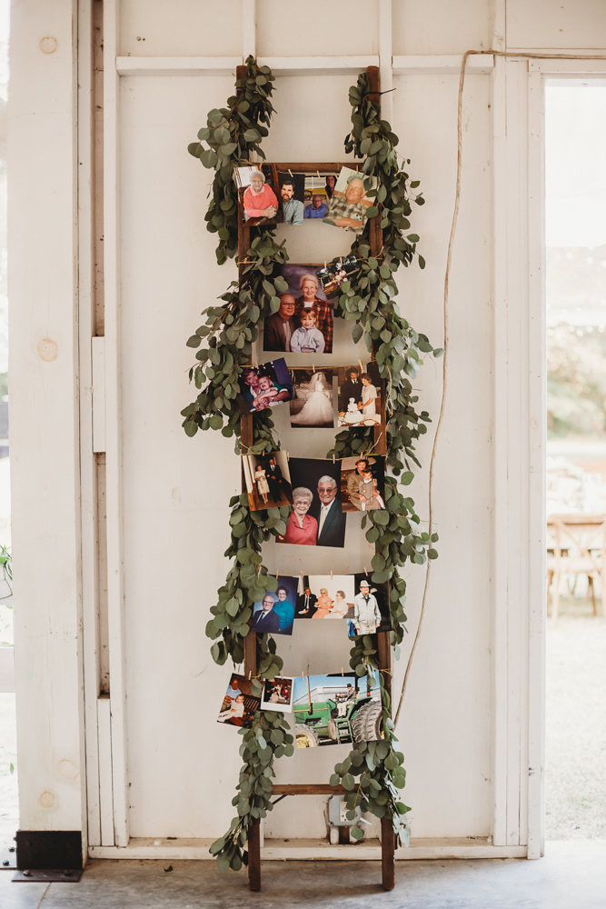 Memory ladder display with vintage family photos and eucalyptus garland at Wavering Place during Morgan and Daniel's wedding day