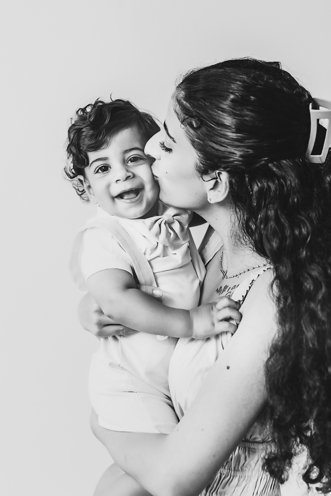 Black and white portrait of mom holding smiling Lucas in soft studio lighting at Reflection Images by Tracy Rowell in Florence SC