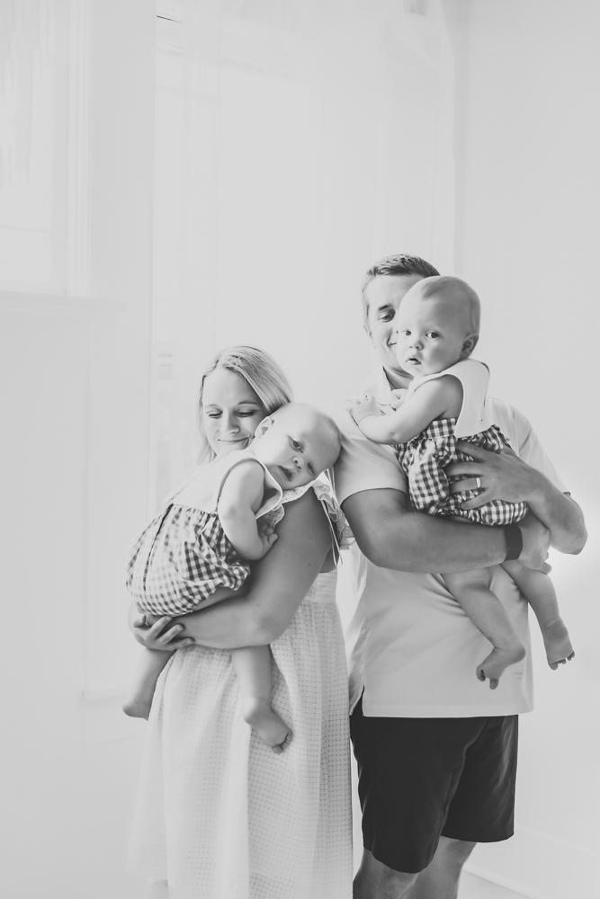 Black and white photo of both parents holding the twins with soft natural light at Reflection Images by Tracy Rowell in Florence SC