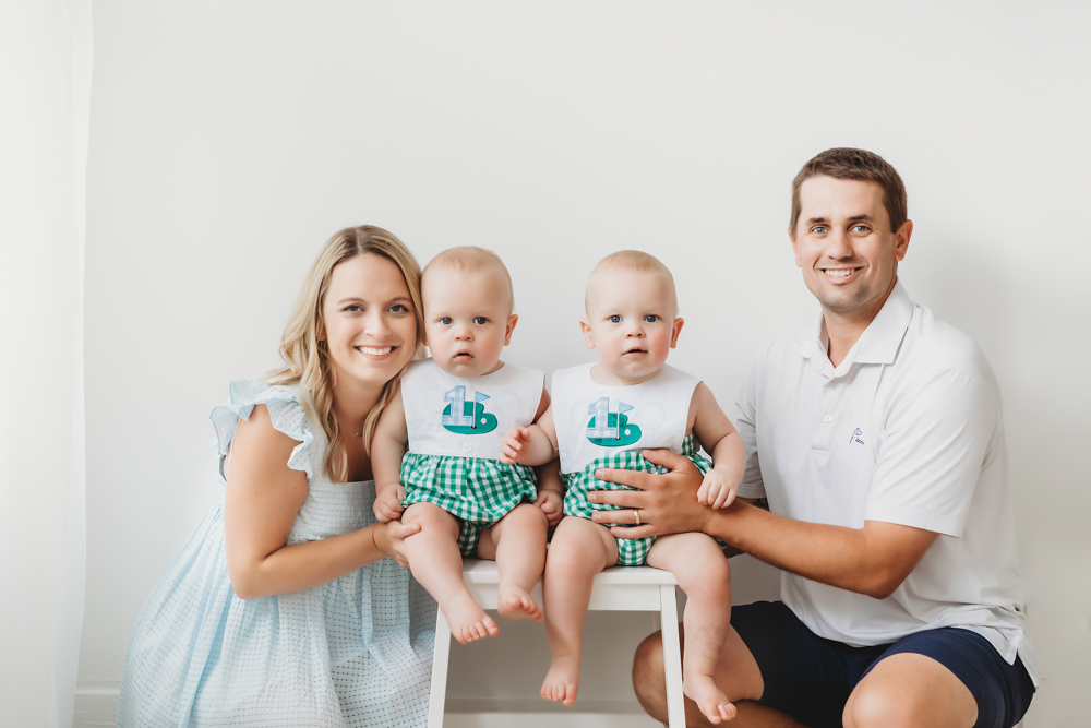 Studio family portrait with parents kneeling by twins sitting on stool at Reflection Images by Tracy Rowell in Florence SC