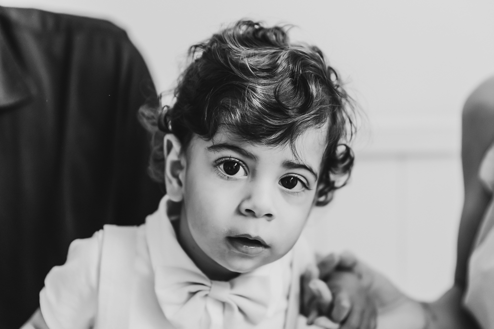 Black and white closeup of Lucas with curly hair and soft expression against a clean studio backdrop at Reflection Images by Tracy Rowell in Florence SC