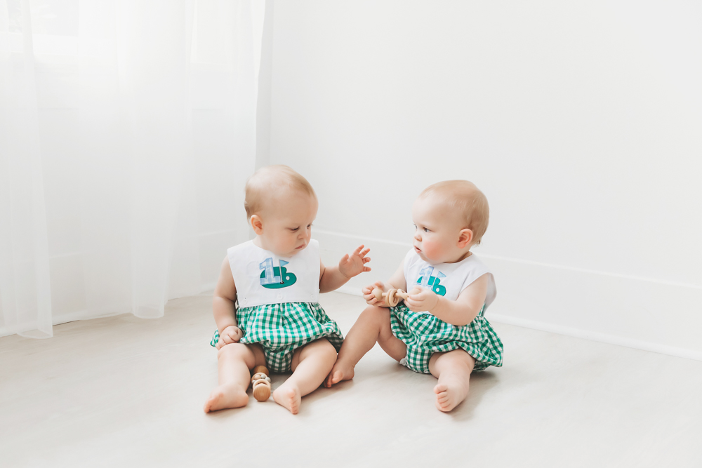 Studio photo of twins interacting with wooden toys on a white floor at Reflection Images by Tracy Rowell in Florence SC