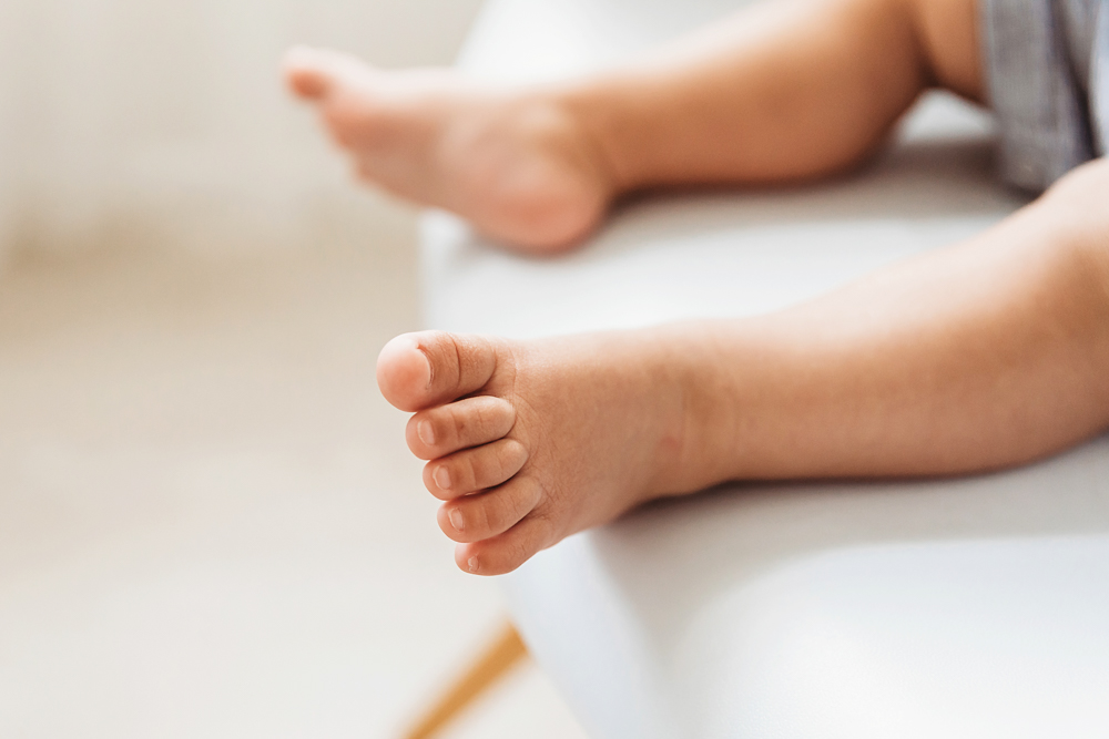 Close detail of Lucass small toes resting on a white chair edge in warm natural studio light at Reflection Images by Tracy Rowell in Florence SC