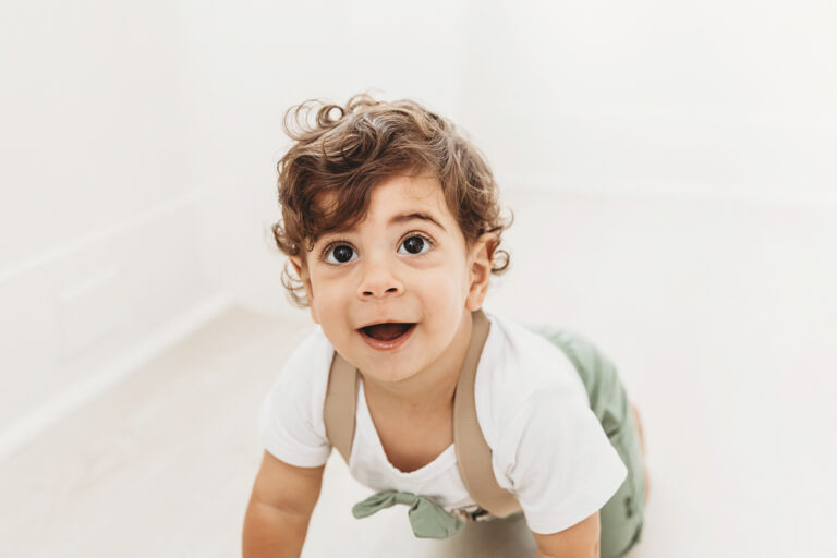 Closeup of Lucas crawling with big expressive eyes and a playful smile in soft natural studio light at Reflection Images by Tracy Rowell in Florence SC