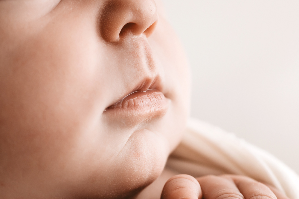 Close-up of peaceful sleeping baby's face with soft features, warm lighting by florence sc newborn photographer