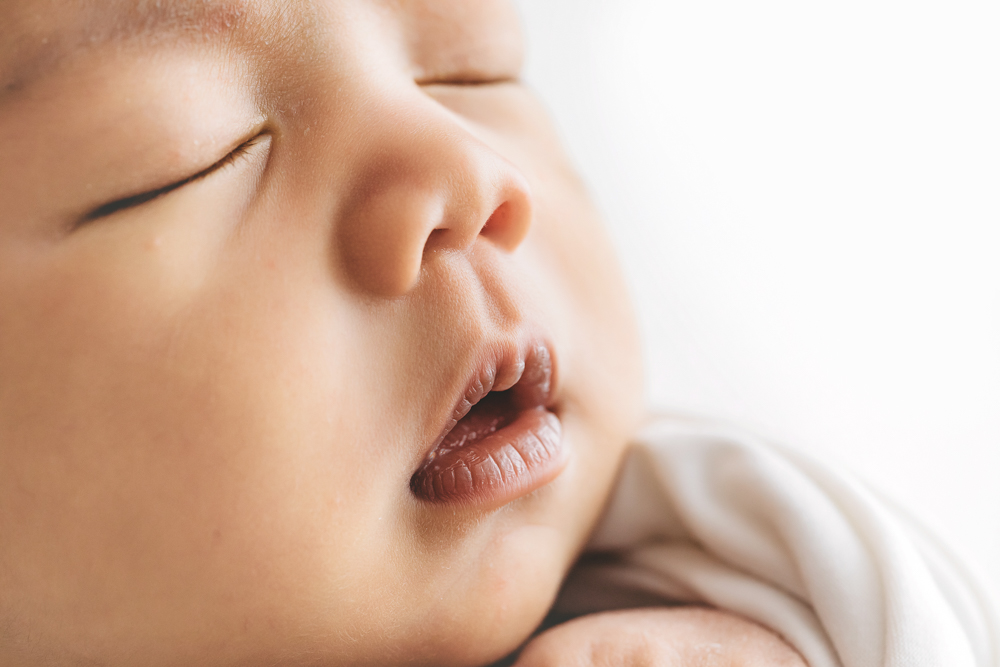 Sleeping baby with peaceful expression in soft natural lighting on white backdrop - Reflection Images by Tracy Rowell