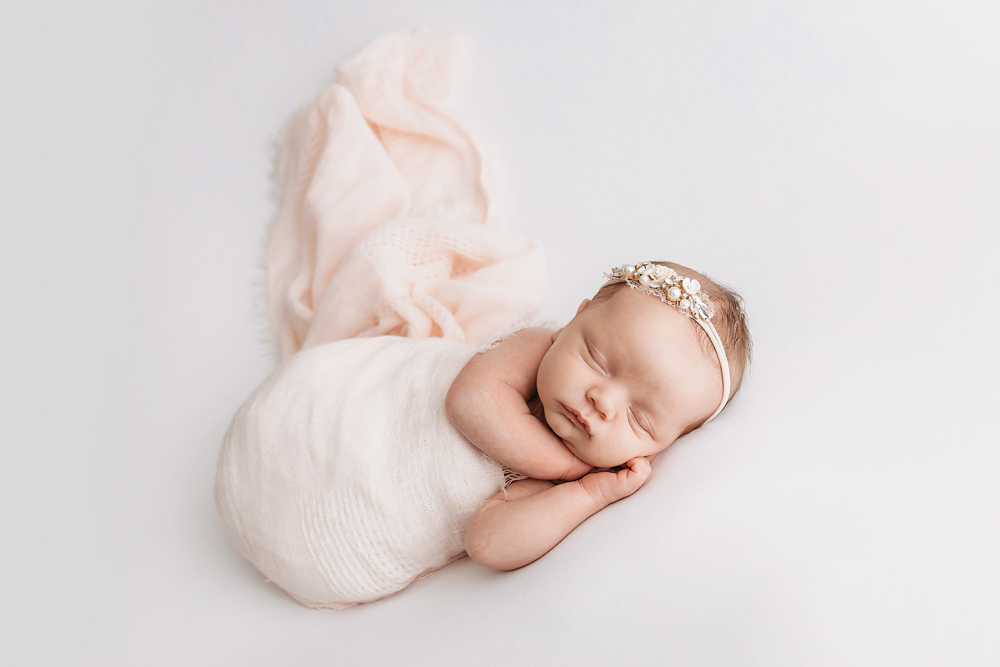 Newborn girl in blush knit wrap with floral headband by Florence SC photographer Reflection Images by Tracy Rowell.