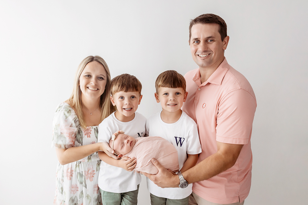 Florence SC family portrait by Reflection Images with mother in floral dress and newborn in dusty rose knit wrap.