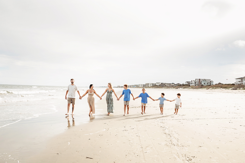 Culpepper family walking hand in hand on Pawleys Island SC beach in coordinating taupe and sky blue outfits.