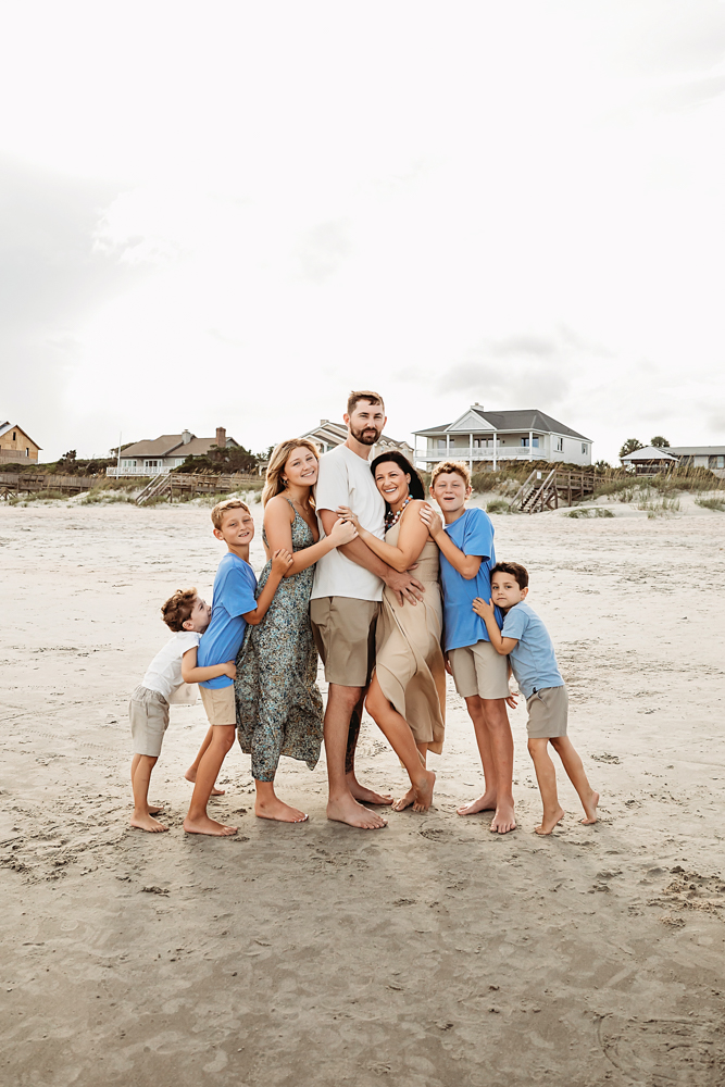 Culpepper family beach photography in Pawleys Island SC featuring blue shirts and taupe shorts with mom in a beige dress.
