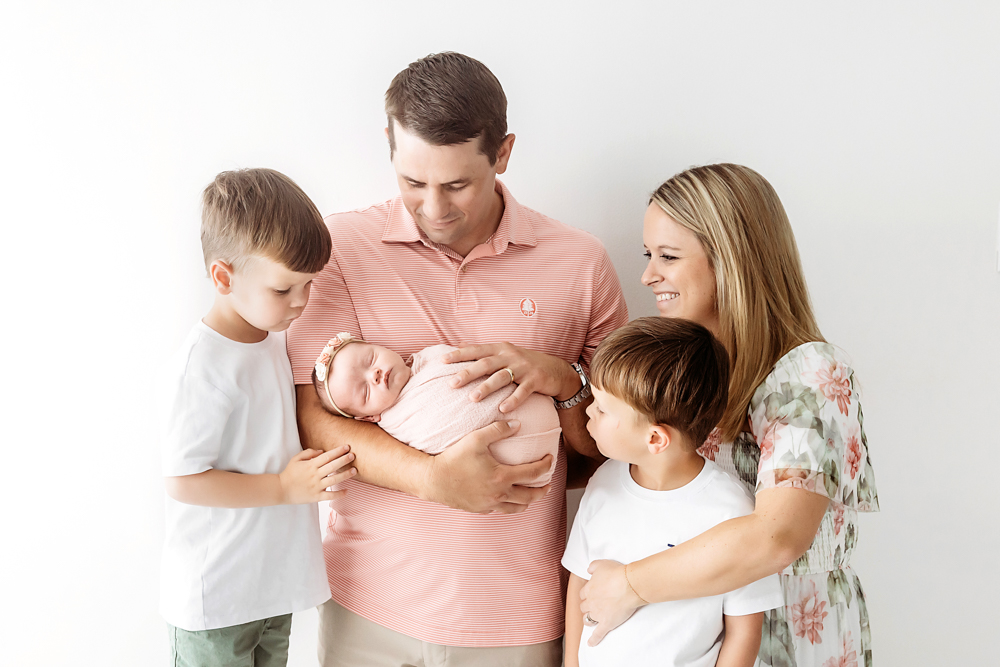 Family poses with newborn in blush knit swaddle by Florence SC newborn photographer Tracy Rowell at Reflection Images.